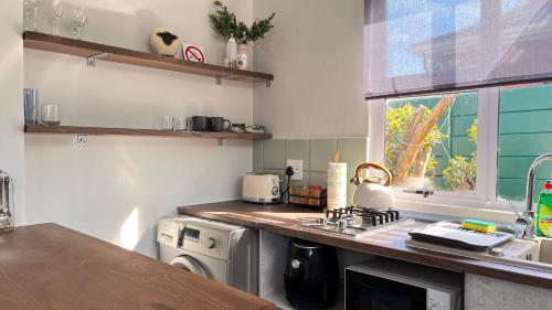 a kitchen with a sink and a stove top oven at Traveller's Inn - Studio Cottage in Walmer
