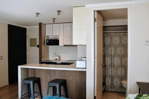 a kitchen with a counter and two stools at Arauco Apartment in Santiago