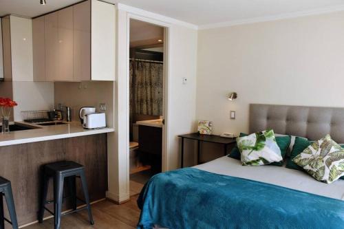 a bedroom with a bed and a small kitchen at Arauco Apartment in Santiago