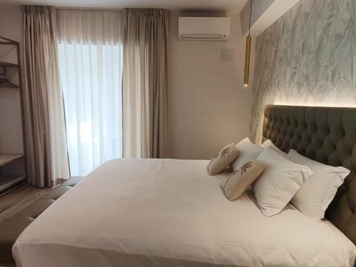 a bedroom with a large bed with white sheets and pillows at Romi Suite in Rome
