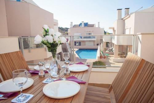 a wooden table with plates and wine glasses on a balcony at Casa Sol in Burgau