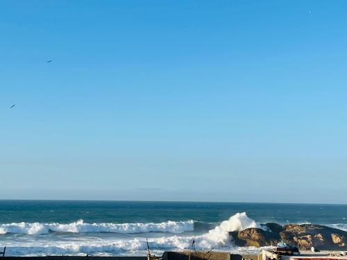 a view of the ocean with waves and rocks at Boho Chic PRIVATE Riad, with Rooftop Ocean view, Fireplace and High speed Internet in Essaouira