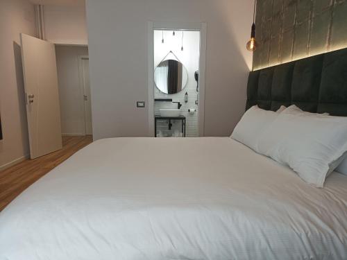 a large white bed in a bedroom with a mirror at Romi Suite in Rome