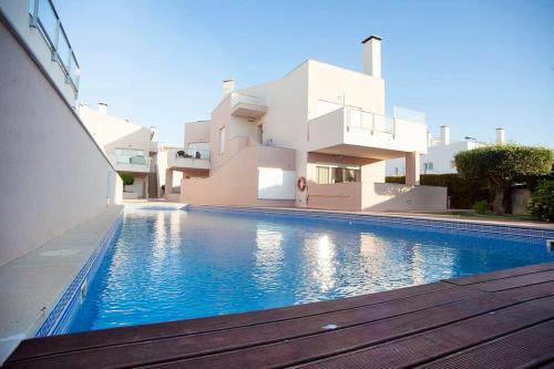 a house with a swimming pool in front of a house at Casa Sol in Burgau