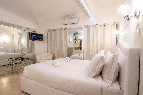 a white bedroom with a white bed and a bathroom at Deluxe Suite Welness in Rome