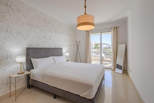 ein Schlafzimmer mit einem großen Bett und einem großen Fenster in der Unterkunft Calm Palmar By W Tenerife in Palm-mar