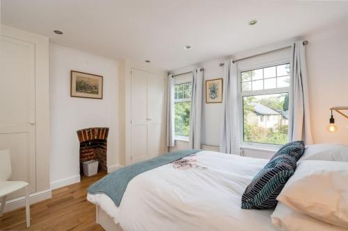 ein Schlafzimmer mit einem großen Bett und einem Kamin in der Unterkunft Beautiful 3 bed Cottage Chorleywood. in Chorleywood
