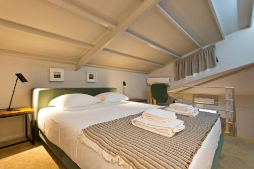 a bedroom with a bed with towels on it at RVA - Gustave Eiffel Apartments in Porto