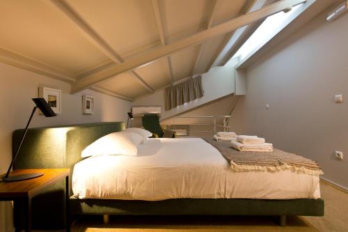 a bedroom with a large bed with a skylight at RVA - Gustave Eiffel Apartments in Porto