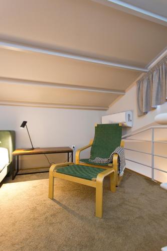a room with a green chair and a table at RVA - Gustave Eiffel Apartments in Porto