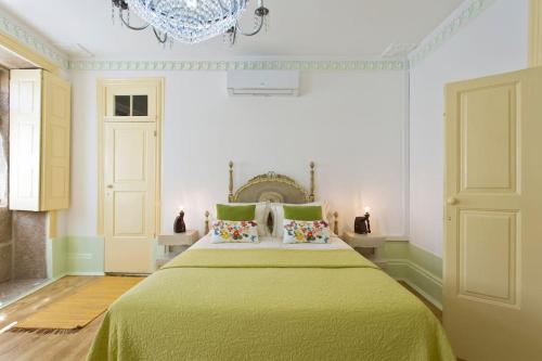 a bedroom with a large bed with a green blanket at HC Villa Douro in Vila Nova de Gaia