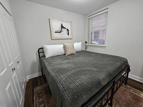 Cama en habitación con ventana en Cozy King Bed Stay at the Historic Inman - 201, en Champaign