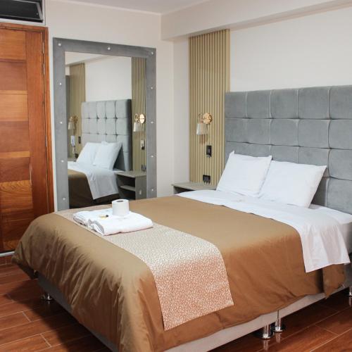 Terra Premium Hotel في هانوكو: غرفة نوم بسرير كبير ومرآة