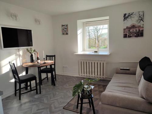 uma sala de estar com um sofá e uma mesa em Linkuva Manor Apartment em Kaunas