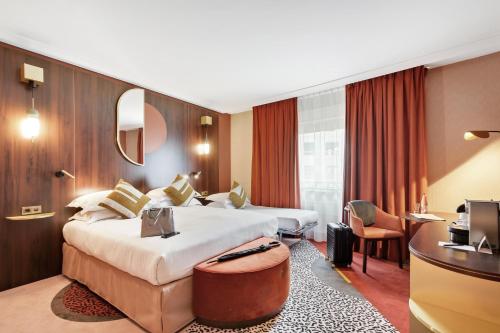 um quarto de hotel com duas camas e uma secretária em Nest Paris La Défense - MGallery em Puteaux