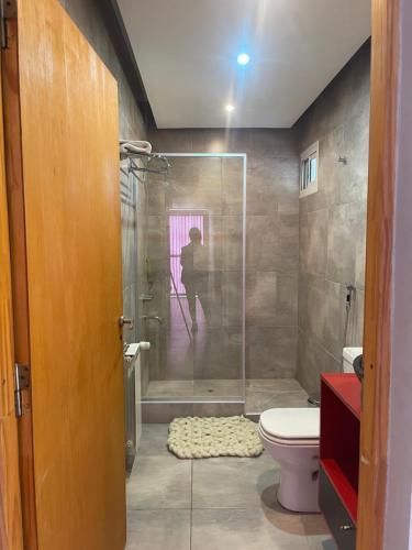 a bathroom with a toilet and a shower with a person in it at Mi casa es tu casa!! in Malargüe