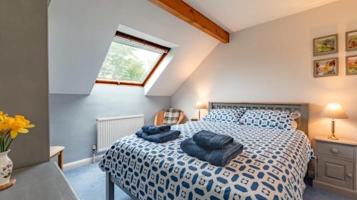 a bedroom with a bed with blue pillows on it at Sheldon Barn in Monyash