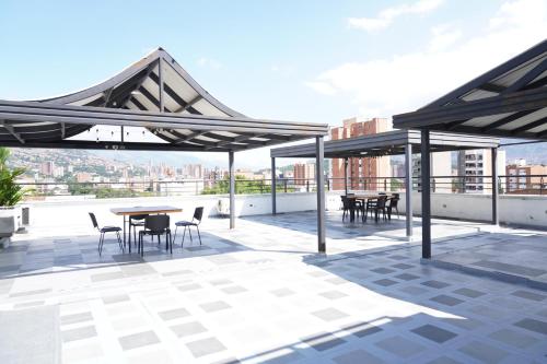 a patio with tables and chairs on a roof at Hotel San Pedro del Fuerte in Medellín