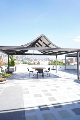 a pavilion with a table and chairs on a roof at Hotel San Pedro del Fuerte in Medellín