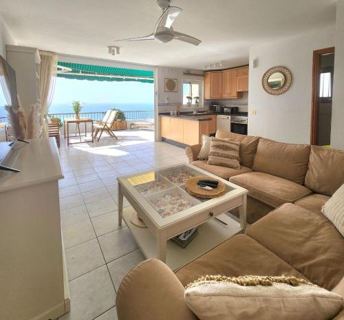 a living room with a couch and a table at Ocean Wave in Acantilado de los Gigantes