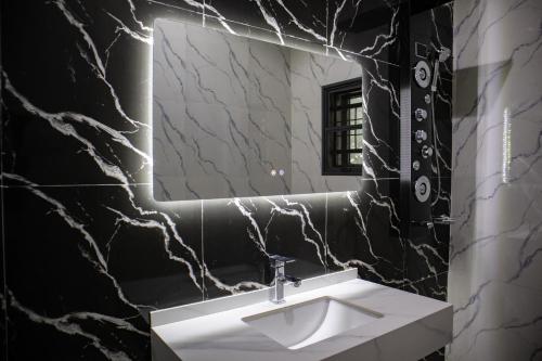 a bathroom with a white sink and a mirror at Pula Pula Luxury Hotel and Suites in Karewa