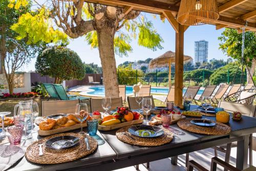 マルベーリャにあるCasa Rio Real Marbellaのテーブル(食べ物、ワイングラス付)