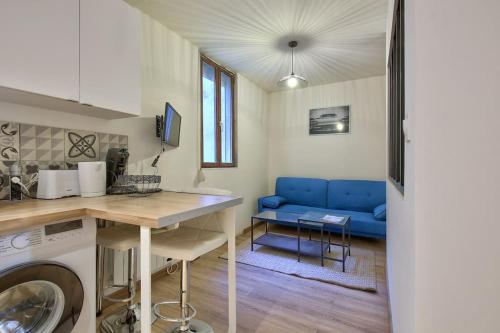Il comprend une cuisine et un salon doté d'un canapé bleu. dans l'établissement L'IRIS 8 min de la Gare Terrasse Netflix, à Nancy