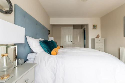a bedroom with a white bed with a stuffed animal on it at Four bedroom townhouse in famous Suffolks area in Cheltenham