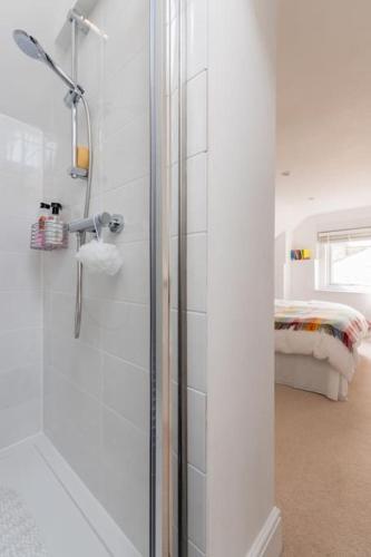 a bathroom with a shower and a bed in a room at Four bedroom townhouse in famous Suffolks area in Cheltenham