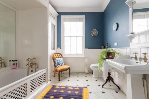 a bathroom with a tub and a sink and a toilet at Four bedroom townhouse in famous Suffolks area in Cheltenham
