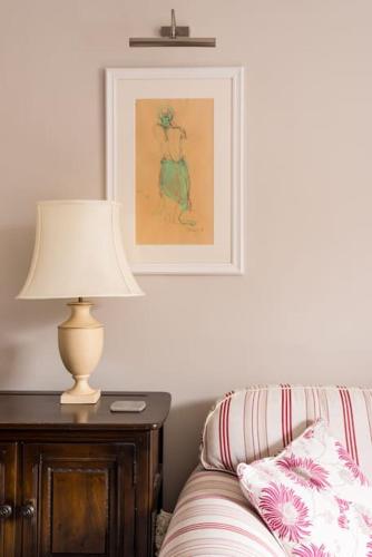 a lamp sitting on a table next to a bed at Four bedroom townhouse in famous Suffolks area in Cheltenham