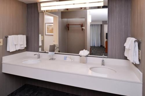 a bathroom with two sinks and a large mirror at Courtyard Charlotte Gastonia in Gastonia