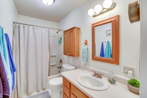 y baño con lavabo, aseo y espejo. en Lake Michigan Home with Private Beach and Deck!, en Menominee