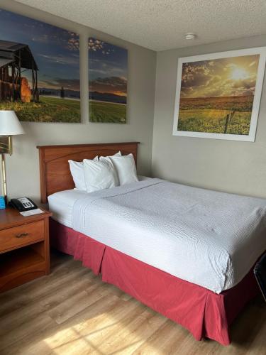 a bedroom with a large bed with a red blanket at Days Inn by Wyndham Turlock in Turlock