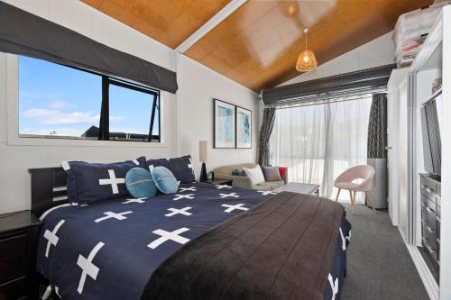 a bedroom with a large bed in a room at Sunnyside Spa Retreat - Mangawhai Holiday Home in Mangawhai