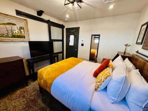 a bedroom with a bed with white sheets and pillows at Neocolonial Nouveau Kensington in Vancouver