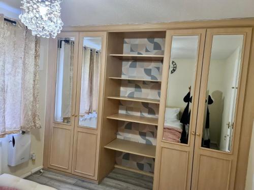 a room with a closet with shelves and a chandelier at Beautiful 2-Bed House in London in London