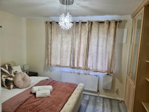 Un dormitorio con una cama grande y una lámpara de araña. en Beautiful 2-Bed House in London en Londres