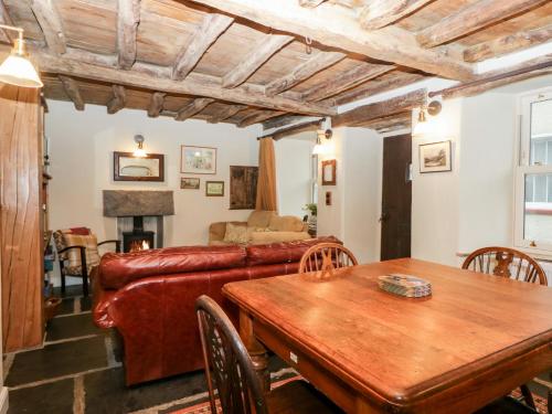 a living room with a leather couch and a table at Eden Vale in Broughton in Furness