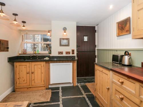 a kitchen with wooden cabinets and a sink at Eden Vale in Broughton in Furness