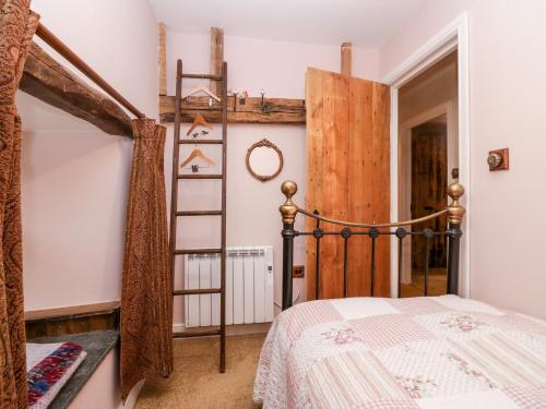 a bedroom with a bed and a wooden ladder at Eden Vale in Broughton in Furness