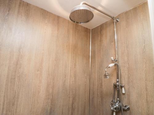 a shower in a bathroom with a wooden wall at Eden Vale in Broughton in Furness