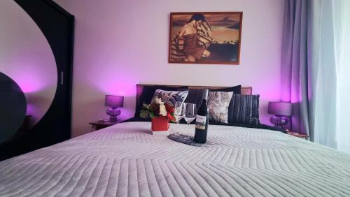 a bed with a bottle of wine and flowers on it at NOWY Apartament Pełen Życia in Białystok