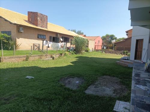 einen Hof mit grünem Gras und einem Haus in der Unterkunft Cobertura Prédio 15 m Ar Livre in Laranjal