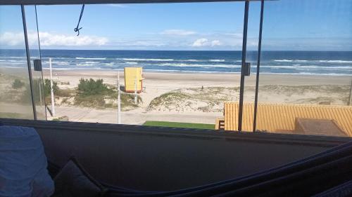 a view of a beach from a room with a window at Cobertura Prédio 15 m Ar Livre in Laranjal