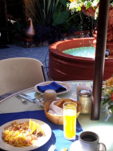 mesa con plato de comida y bañera de hidromasaje en Hotel Palacio de Moctezuma, en San Cristóbal de Las Casas