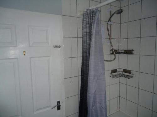 a shower with a shower curtain in a bathroom at 3 bedroom house, Market Deeping -nr Peterborough, Stamford, Spalding in Market Deeping