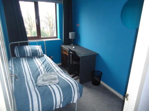 a blue room with a bed and a desk at 3 bedroom house, Market Deeping -nr Peterborough, Stamford, Spalding in Market Deeping