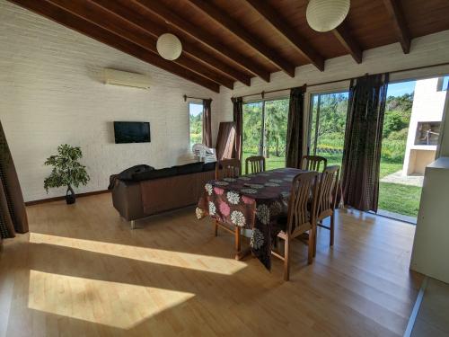 a dining room with a table and a couch at Portal Del Campo in Piriápolis