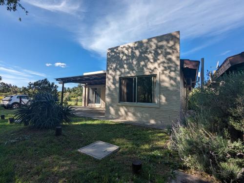 una pequeña casa con una ventana en un patio en Portal Del Campo en Piriápolis